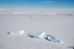 6: Vista desde el helicóptero, sobrevolando la banquisa y los icebergs, al fondo el continente Antártico
